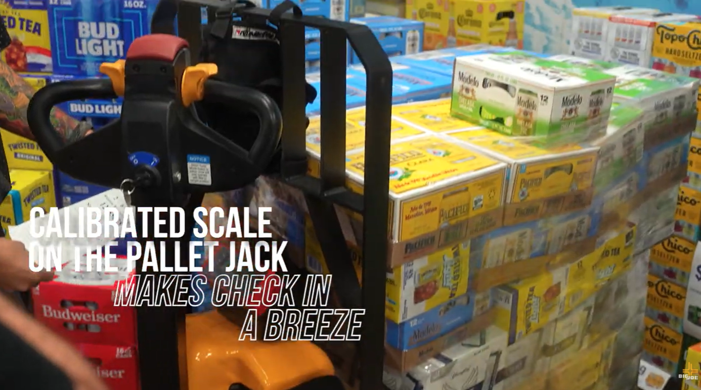 Customer using a RAVAS electric pallet jack scale for weighing and transporting pallets in a warehouse.